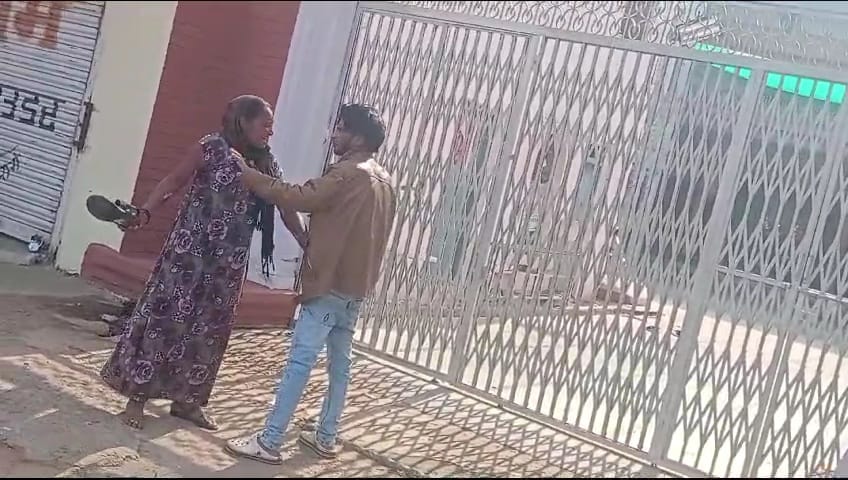 युवक को चप्पलों से पीटती महिला