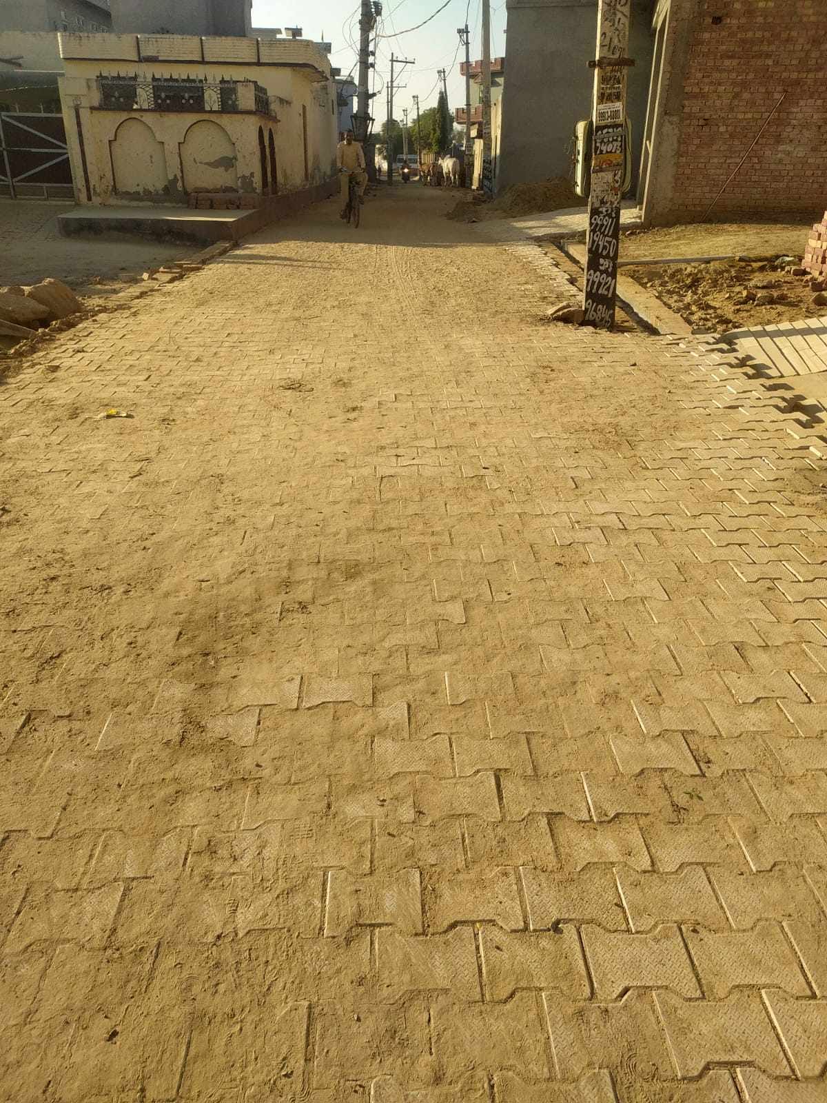 Interlocking tiles being laid in the main street of Gajuwala
