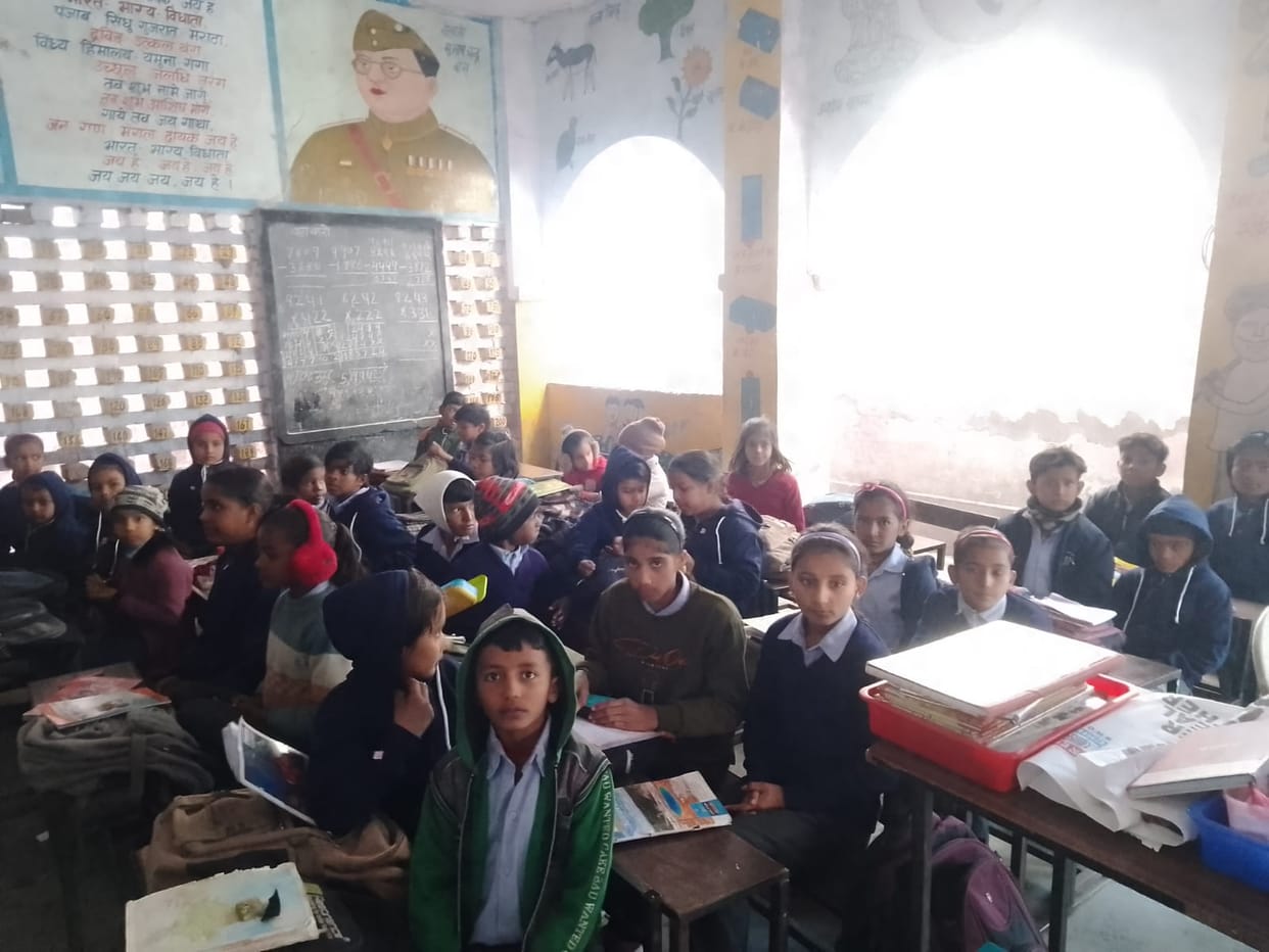 Due to lack of rooms in New Mandi Primary School, students are forced to study sitting in the verandah.