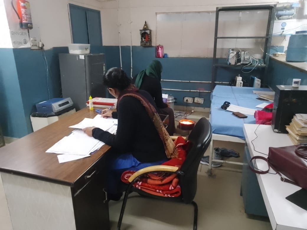 Windows of women's ward broken, staff sitting near heater