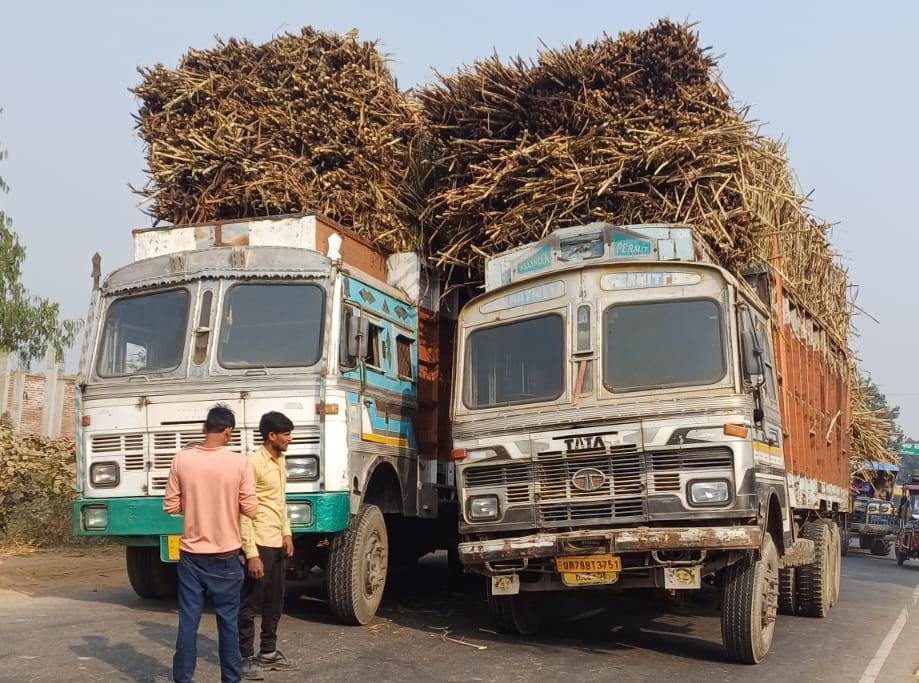 When the body of the overloaded truck tilted, another truck was parked next to it.