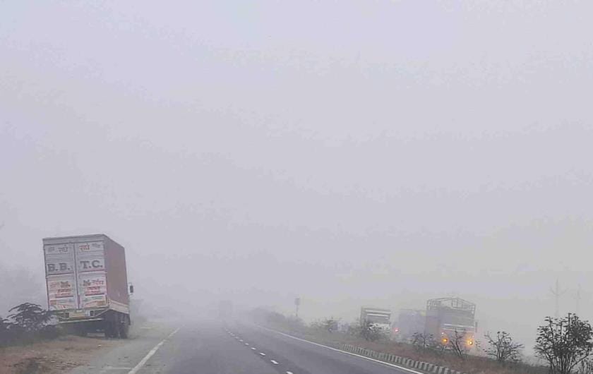 Highway wrapped in fog, vehicles crawling