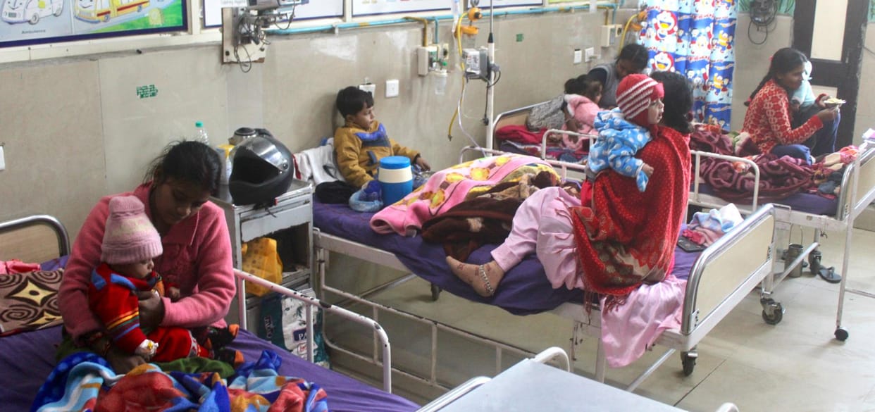 Ward full, two children each on one bed, long wait for medicine