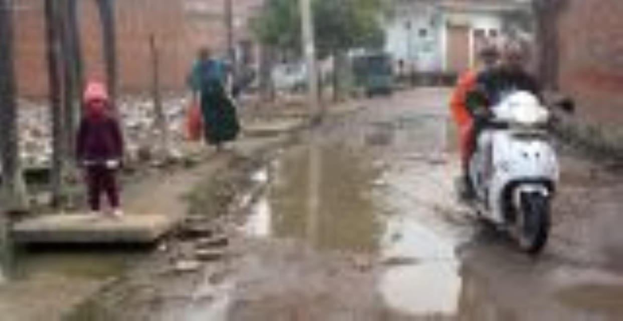 People escaping from the water filled potholes on the road in Ram Nagariya. Dialogue