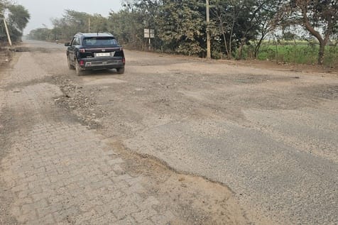 The road is full of potholes, making travel difficult