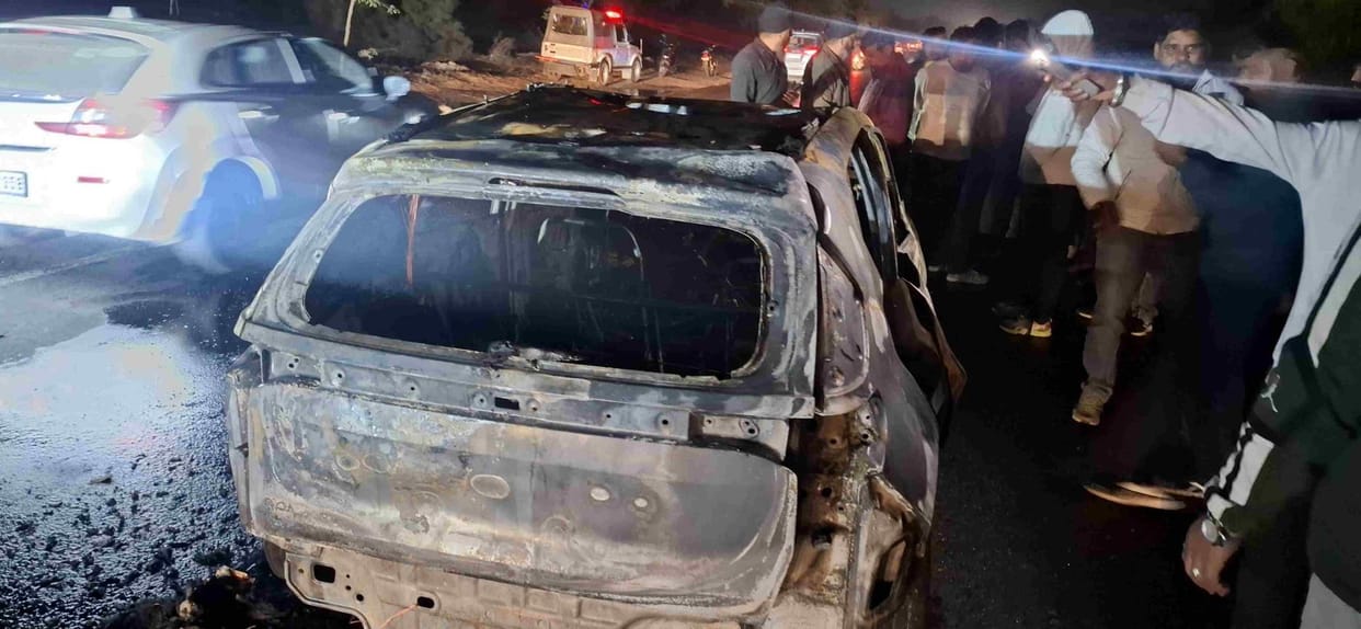Hisar. Burnt car in front of Government Polytechnic College on Delhi Road and crowd of people present at the spot.