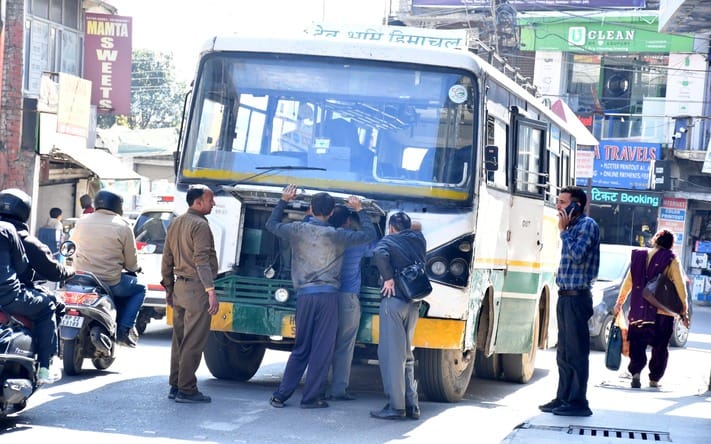 Wheels of government bus stopped in the middle of the road at Nadaun Chowk