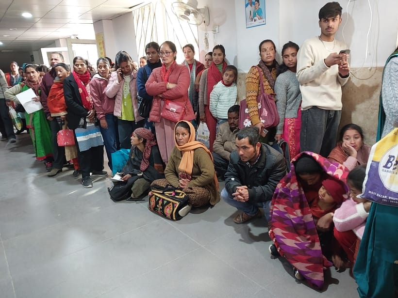 Women kept waiting sitting on the floor with children