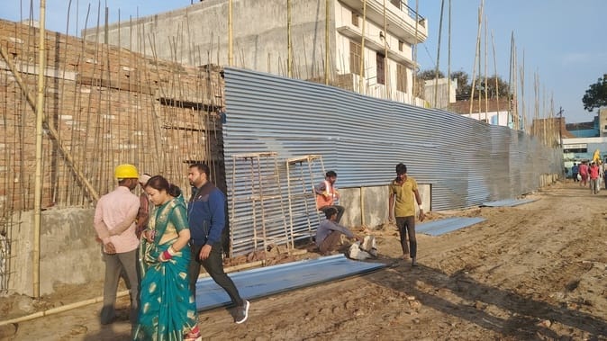 The boundary of Shiv temple corridor is being closed by placing tin.