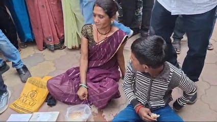 जमीन पर बैठी महिला