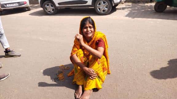 सड़क पर बैठकर रोती महिला 