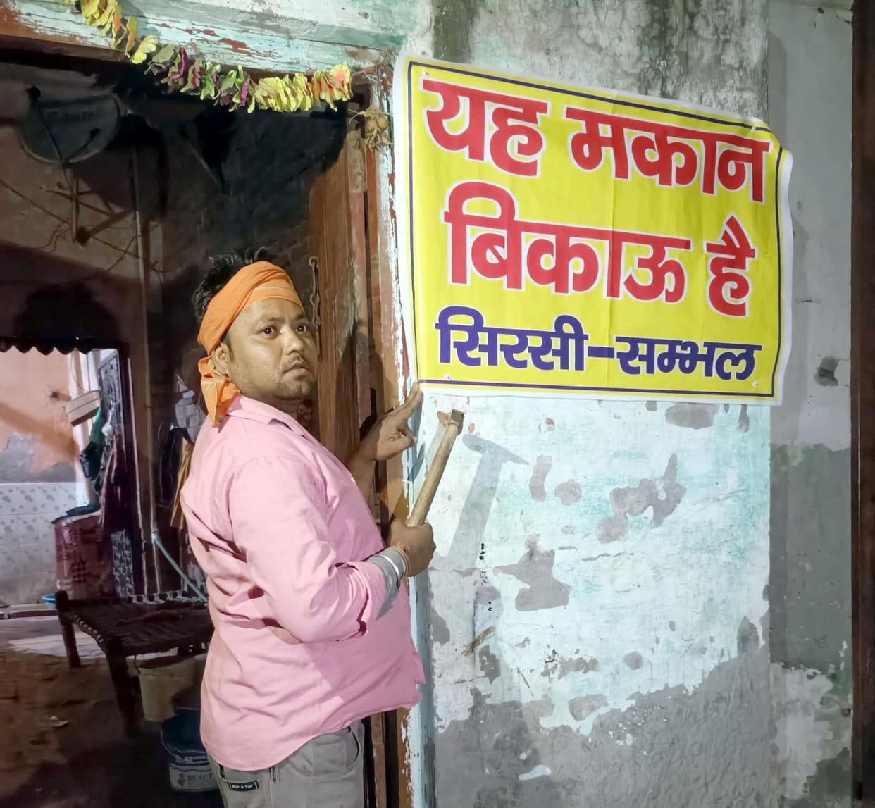 People troubled by illegal occupation of temple land put up banners on their houses saying 'Houses for sale'