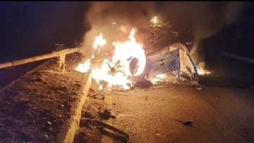 The car overturned on the highway after hitting the divider and caught fire