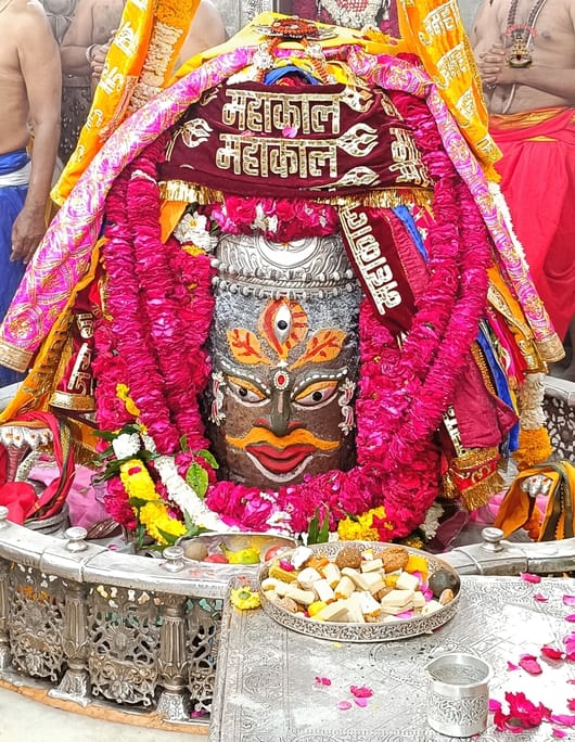 Baba Mahakal decorated with ashes, his third eye opened, posters put up in the temple