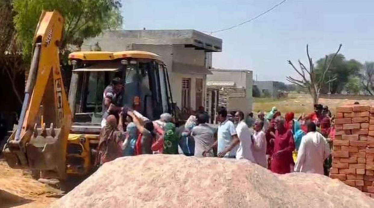 Villagers scuffle with the workers who had come to construct the drain.