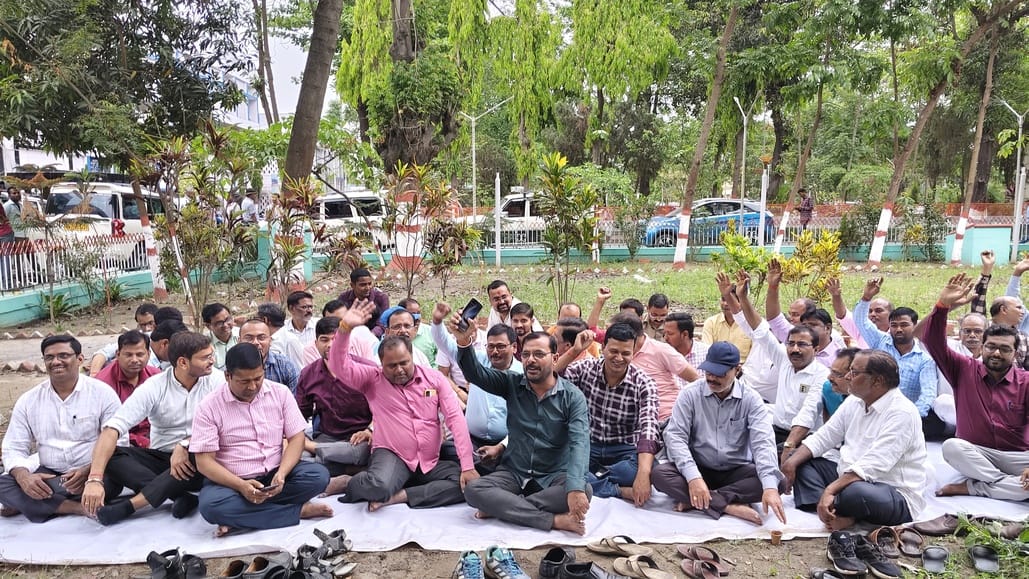 मधेपुरा कलेक्ट्रेट परिसर में धरना पर बैठे कर्मी। फोटो - अमर उजाला डिजिटल