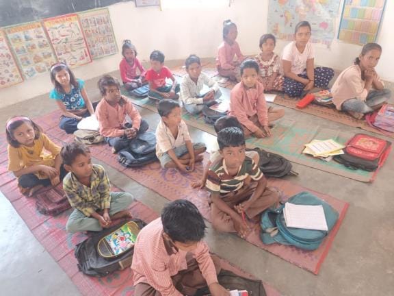 Children are studying sitting on mats in the school next to the BSA office