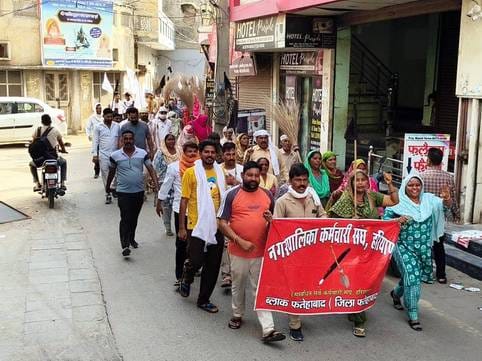 Sanitation workers took to the streets with brooms and black flags in reverse to express their protest
