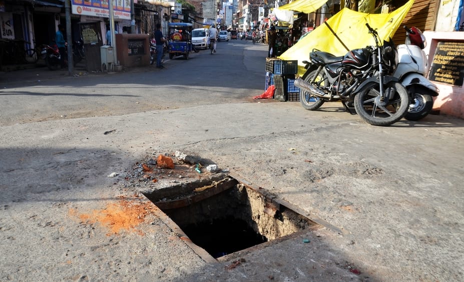 Open drains and potholes on the road pose a risk to life
