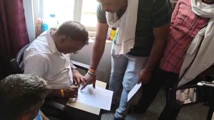 रिश्वत लेते पकड़े गए पटवारी से फॉर्म भरवाती लोकायुक्त की टीम।