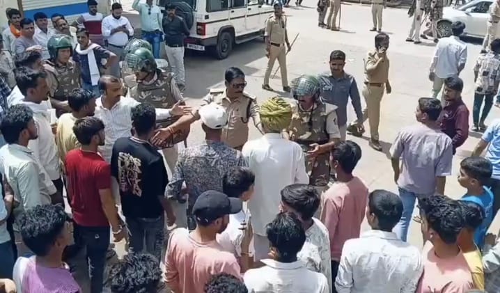 प्रदर्शनकारियों को समझाइश देते पुलिस अधिकारी