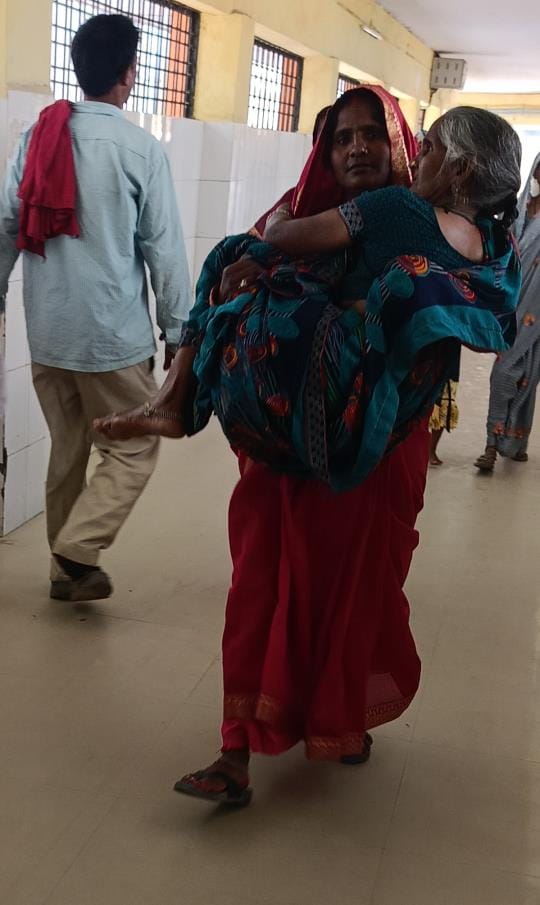 Stretcher was not available, daughter carried her mother in her lap for X-ray