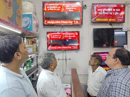 मथुरा। जम्मू में हमले के बाद होली गेट पर एक दुकान में टीवी देखते लोग।