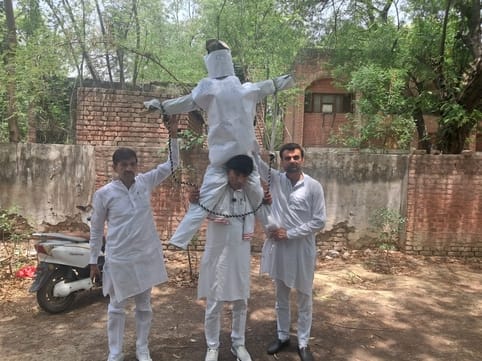 District councilor demonstrated by carrying the effigy of Panchayati Raj on his shoulder