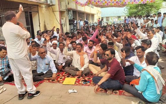 Employees sit on strike outside the Superintending Engineer's office
