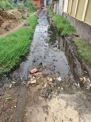 Water filled on the road in Pali Anandgarhi, people passing through mud