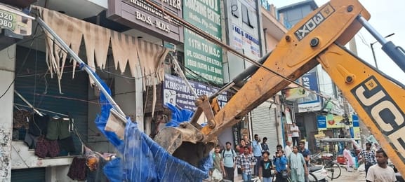 Bulldozer runs on illegal encroachment, shopkeepers angry