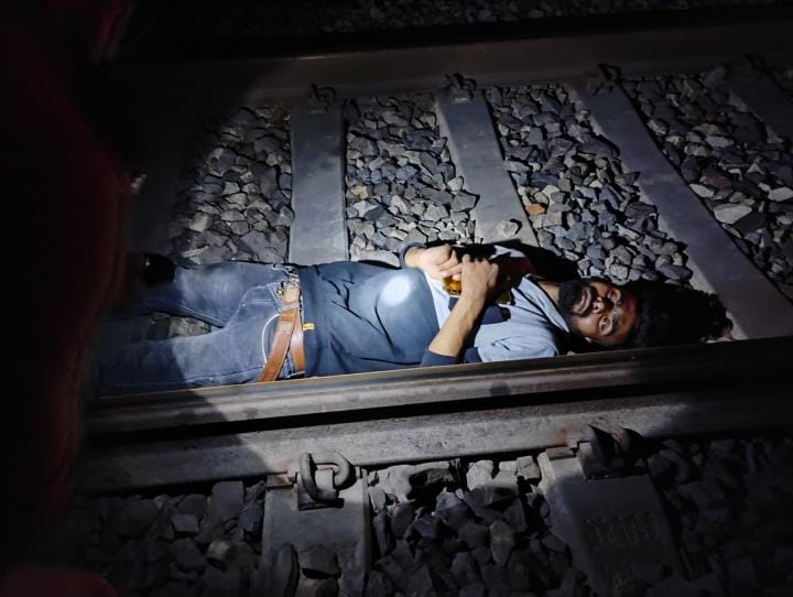 Police saved the life of a young man who was lying on the railway track to commit suicide