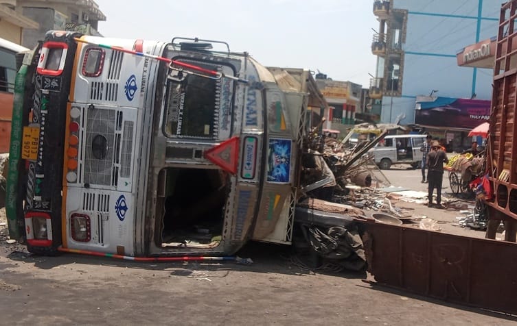 Truck overturned after hitting divider, driver injured