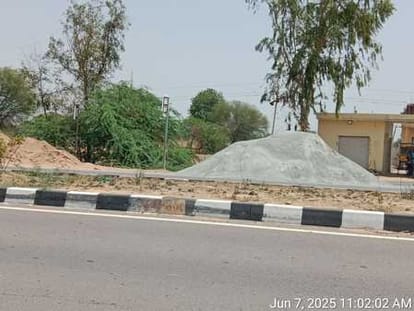 Piles of dust and sand are placed on the side of the highway