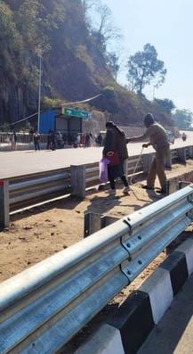 Vehicles speeding on the four-lane road... pedestrians walking on their knees