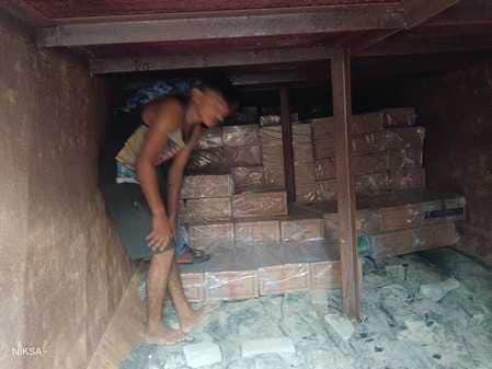 डंपर के भीतरी भाग में भरे शराब के कार्टन