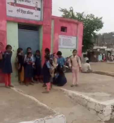 स्कूल में लटका ताला, बाहर खड़ बच्चे।