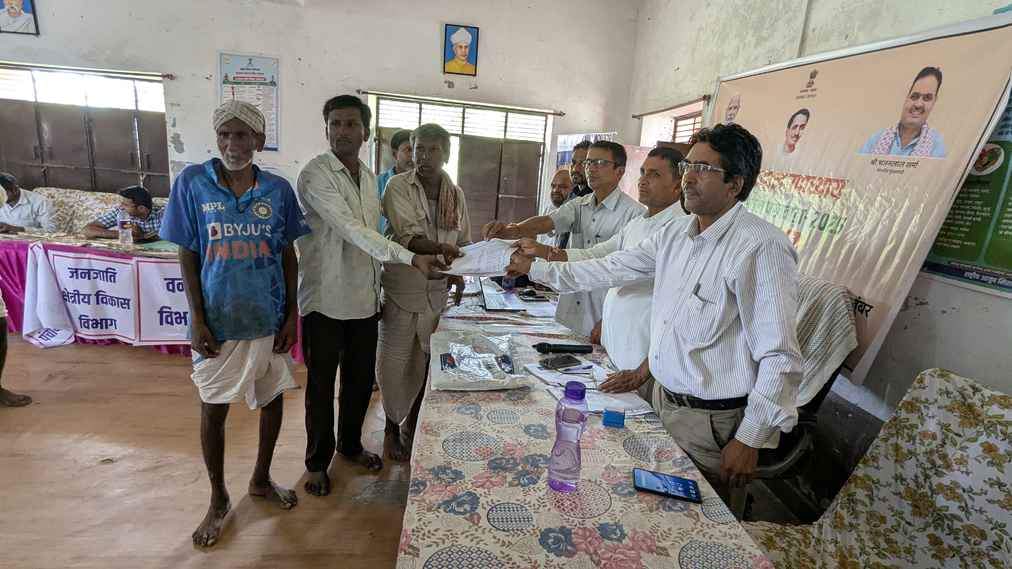 शिविर में आपसी सहमति के बाद बंटवारे का आदेश प्राप्त करते किसान