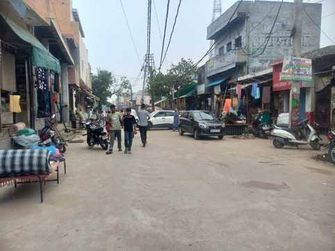 People are parking their vehicles in front of shops in the market instead of parking