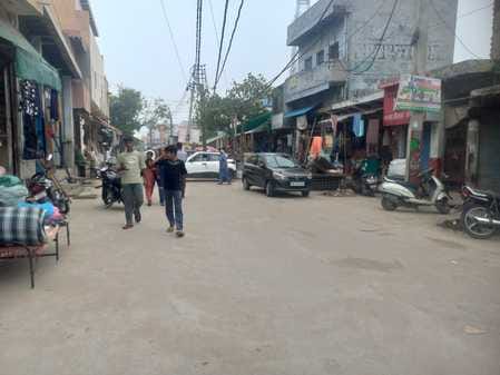 Shopkeepers, hawkers and vehicles occupy the footpath
