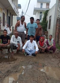 Protested by sitting in mud due to non-construction of road