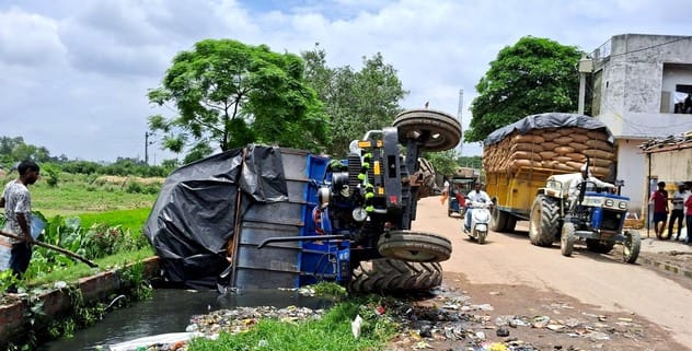 A tractor-trolley loaded with corn fell into a drain near the railway gate