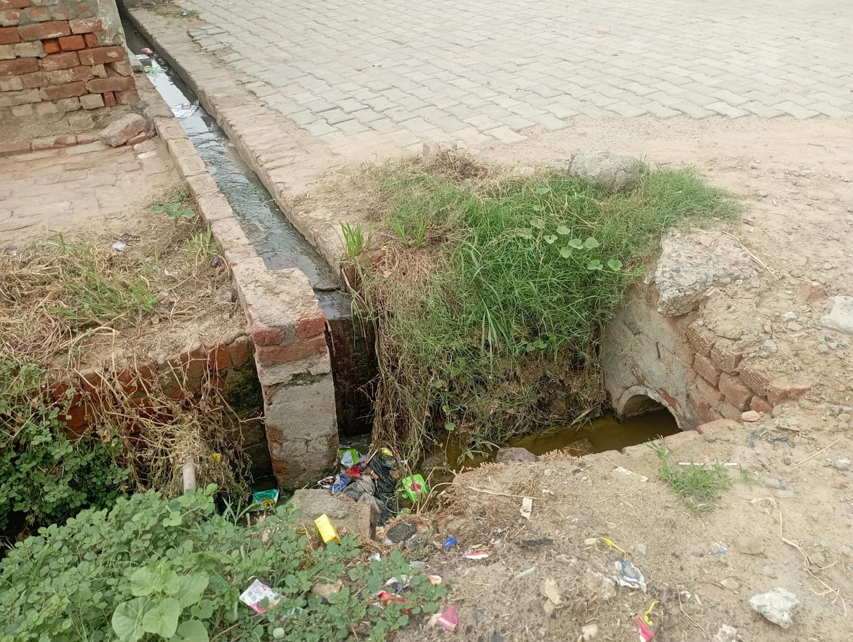 Open manholes and broken chamber lids in Ding Mandi village