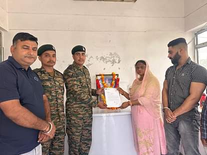 कारगिल शहीद पवन कुमार के परिजनों को सम्मानित करते सेना के जवान । स्रोत : जागरूक पाठक