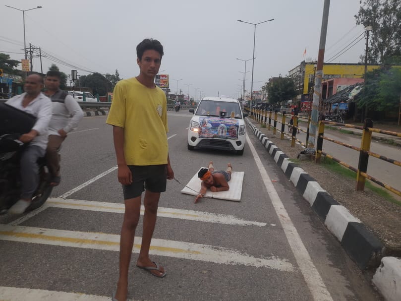 A Shiv devotee is travelling by lying on the highway carrying Ganga water from Haridwar