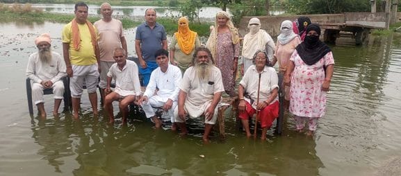 Demonstration by putting cot and chair in contaminated water filled in the street