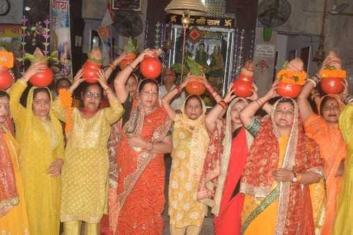 Women came out wearing yellow clothes and carrying urns on their heads