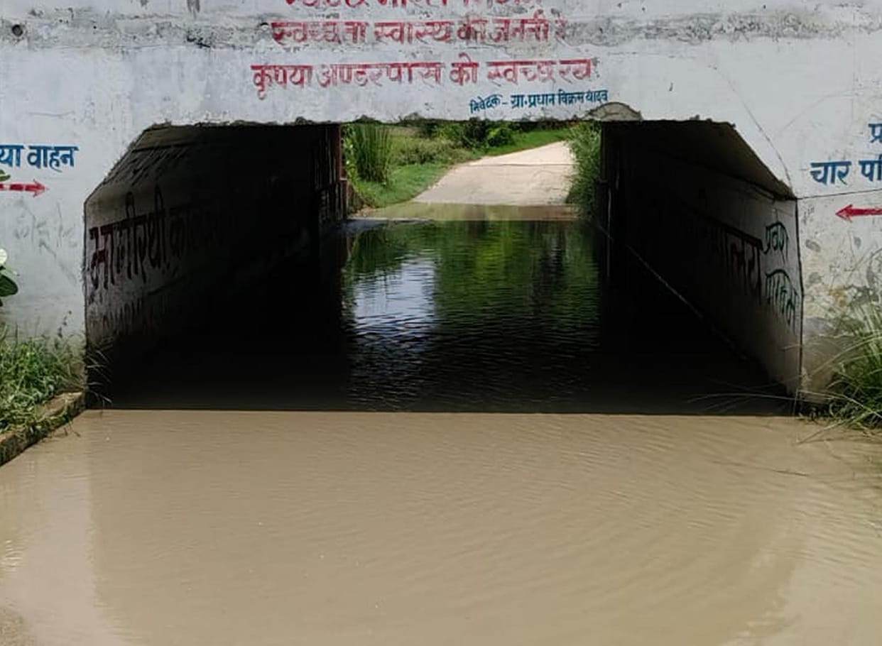 The culvert is filled with water, people are crossing the railway track risking their lives