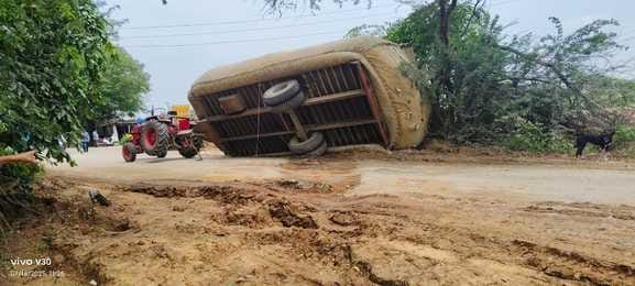 A tractor-trolley loaded with straw overturned, a major accident averted