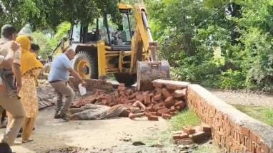 A woman lay in front of a bulldozer removing encroachment
